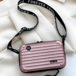 Mini bolso rosado tipo maleta con correa negra "Forever Young".