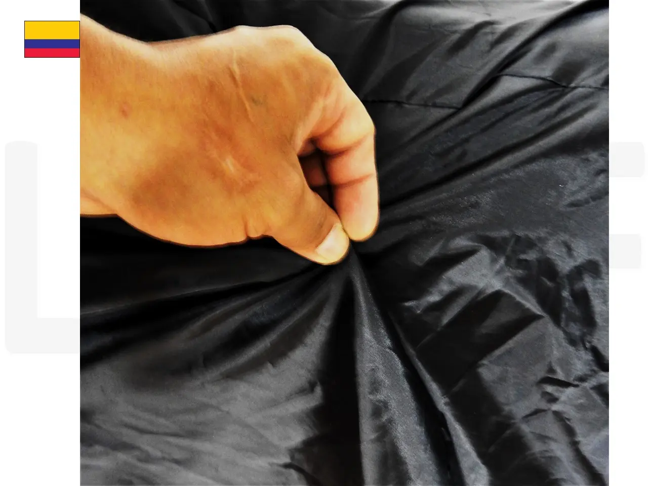 Pijama para moto forrada semi impermeable, vista detallada de la mano sujetando la tela.