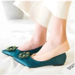 Set X2 Medias Ultra Comfort: pies delicados en zapatos planos verde esmeralda con adornos brillantes.