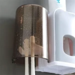 Soporte doble para cepillos con dispensador, montado en pared, diseño moderno.