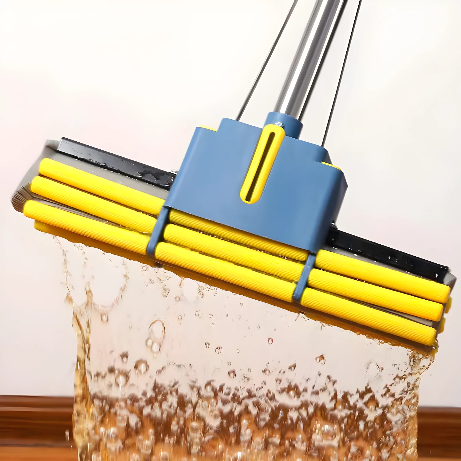 Trapeador de esponja absorbente amarillo y azul sumergiéndose en agua, salpicando líquido.