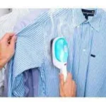 Plancha portátil Tobi de vapor para ropa de rayas azules, planchando una camisa con una mano.