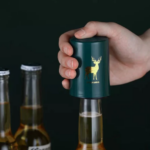 Destapador automático para botellas con diseño de ciervo dorado, abriendo cerveza con una mano.