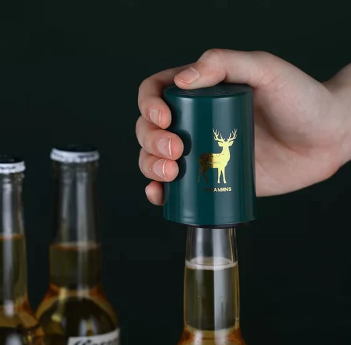 Destapador automático para botellas con diseño de ciervo dorado, abriendo cerveza con una mano.