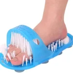 Pie de persona usando masajeador de pies azul con cerdas para limpieza y exfoliación.