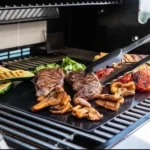 Láminas para asar BBQ con filetes, zucchini y pimientos en la parrilla.