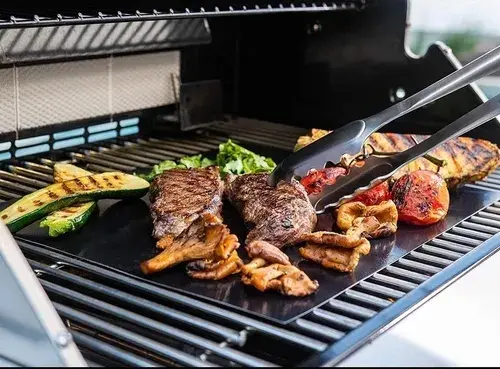 Láminas para asar BBQ con filetes, zucchini y pimientos en la parrilla.