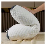 Almohada cervical 3D Desconso blanca con textura hexagonal, sostenida por una mano.