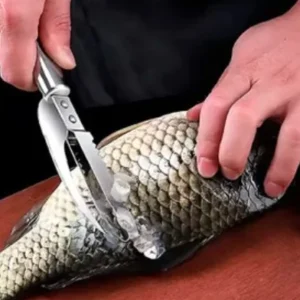 Persona usando cuchillo para quitar escamas de pescado crudo fresco.