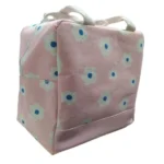 Lonchera térmica de tela rosa con asas y diseño floral blanco con centro azul.