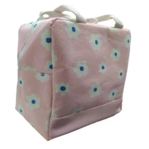 Lonchera térmica de tela rosa con asas y diseño floral blanco con centro azul.