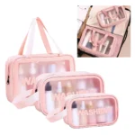 Cosmetiquera rosa de viaje en set de tres tamaños, transparente con asas.