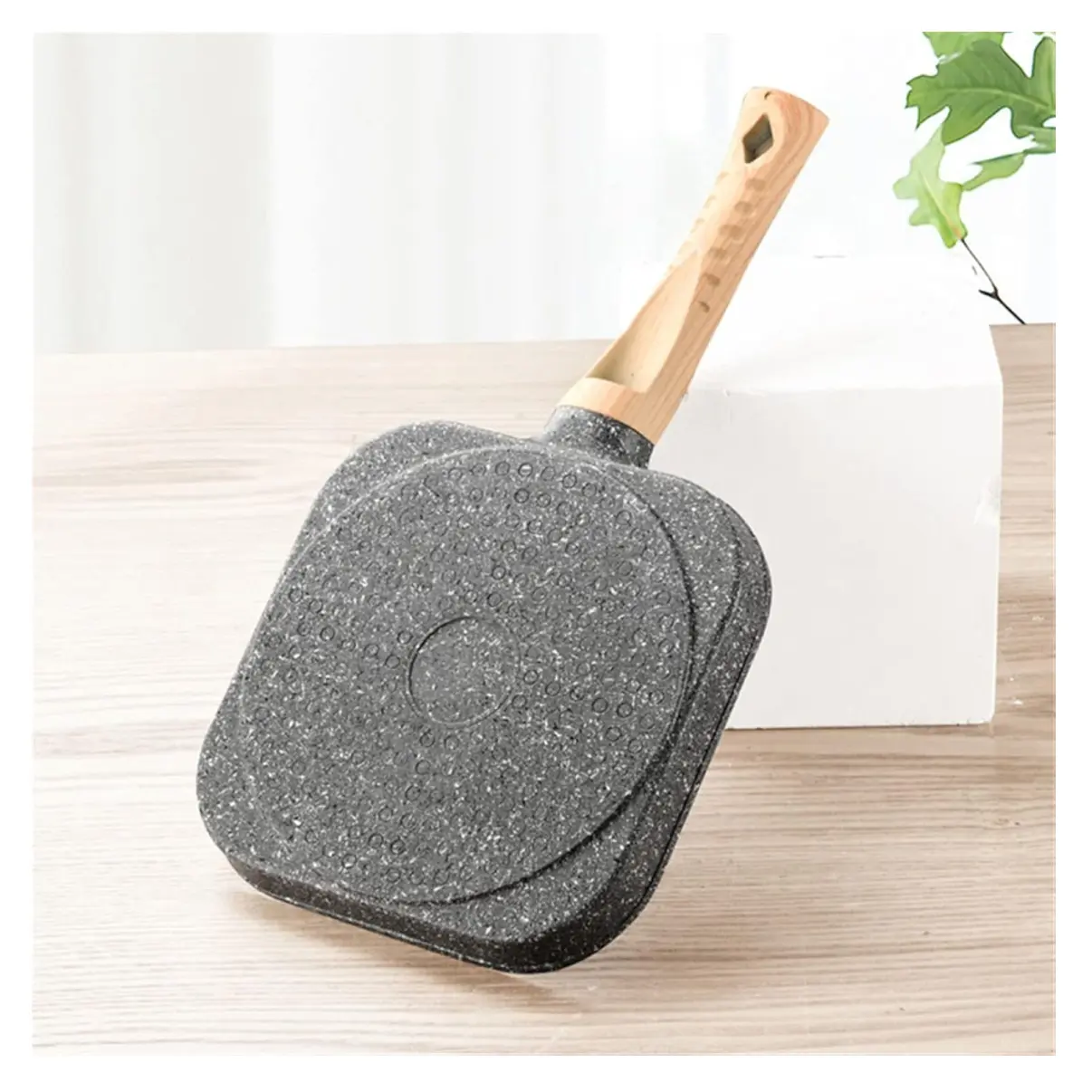 Sartén con forma de corazón, mango de madera y acabado moteado gris.