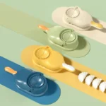 Máquina para hacer dumplings y empanadas en azul, verde y amarillo, con empanadas terminadas.