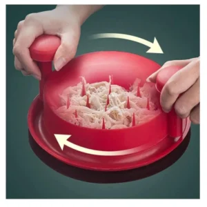 Desmechador de pollo en acción: manos girando el utensilio rojo para desmenuzar carne.