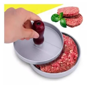 Molde para hamburguesas presionando carne cruda con un accesorio de mango rojo.