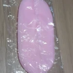 Medias spa hidratantes de silicona rosa, envueltas en plástico, sobre superficie de madera.