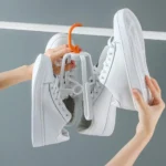 Gancho secador para colgar zapatillas blancas, ideal para secar al aire y organizar calzado.