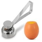 Cortador de huevos de metal brillante abre la cáscara de un huevo cocido.