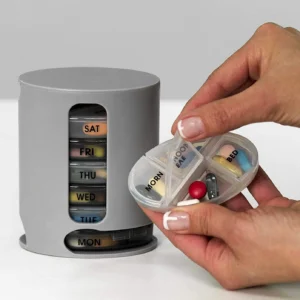 Pastillero Pill Pro gris para 7 días con compartimentos para mañana, mediodía, tarde y noche, con una mano mostrando cápsula…