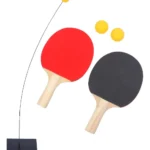 Entrenador de tenis de mesa con raquetas roja y negra, pelotas y base con varilla flexible.