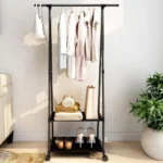 Organizador de ropa con ruedas, 2 estantes, 5 prendas, 2 pares de zapatos y 1 bolso blanco colgado.
