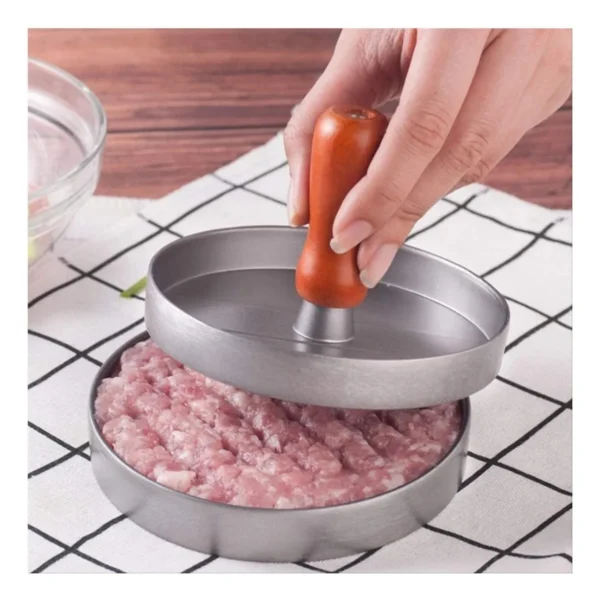 Molde para carne de hamburguesa con prensa de madera aplastando carne picada en forma circular.
