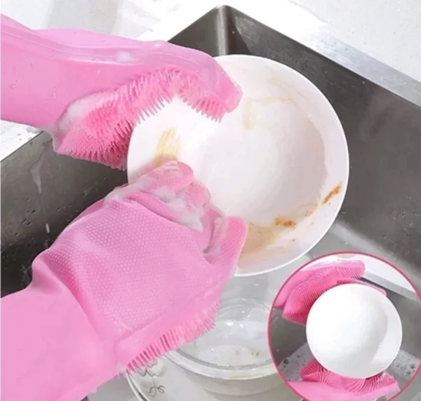 Guantes de silicona rosa con cerdas integradas para lavar platos y vajilla en el lavaplatos.
