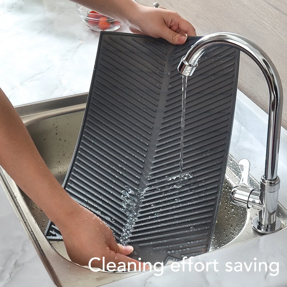 Tapete de cocina multifuncional gris inclinado bajo un grifo chorreando agua.