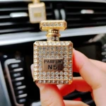 Ambientador para carro diseño perfume Channel N5, dorado con incrustaciones, lujo automotriz.