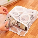 Bolsa de malla blanca para lavar zapatos, con compartimentos interiores y dos zapatillas dentro.