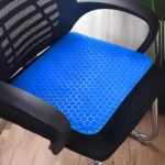 Cojín de gel azul con diseño de panal hexagonal, ergonómico y ortopédico, colocado en silla de oficina.