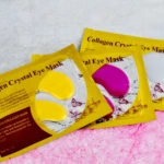 Pack de 3 mascarillas para ojeras de colágeno, con parches amarillos y rosas, sobre fondo texturizado.