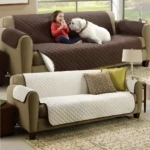 Cubre sofá de 3 puestos marrón con niña y perro, y otro blanco con cojines.