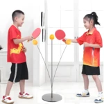 Niños jugando tenis de mesa con un entrenador de pelota giratoria, equipo deportivo para entrenamiento.