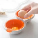 Hervidor de huevos para microondas con un huevo y clara separada en recipiente naranja.