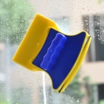 Limpiador de vidrio magnético amarillo y azul limpia gotas de agua en la ventana.