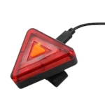 Linterna trasera triangular roja para bicicleta con botón de encendido naranja y cable USB.