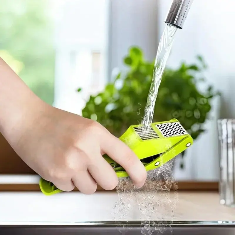 Picador triturador de ajo verde bajo el chorro de agua, fácil de limpiar.