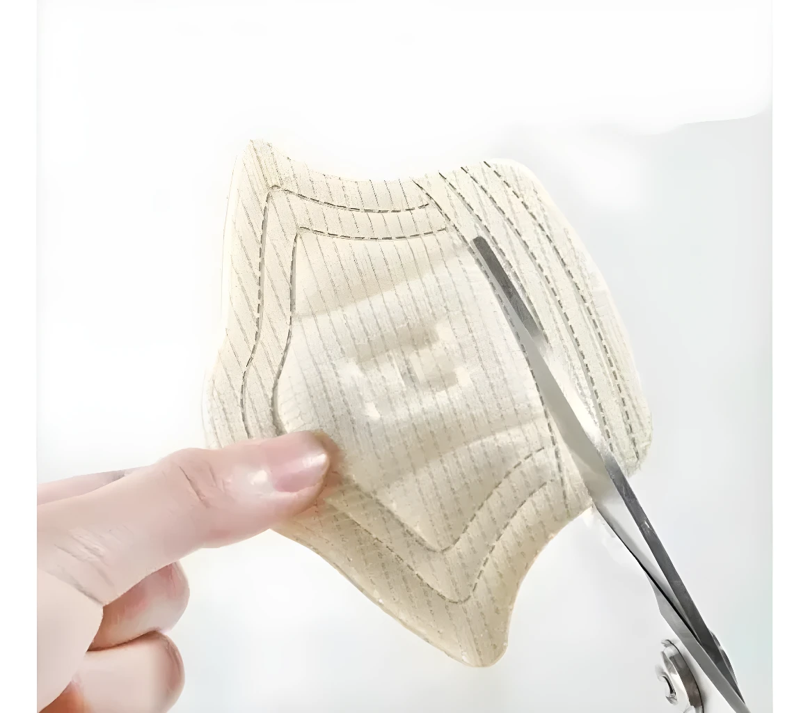 Set x2 pares de plantillas ortopédicas personalizables en beige, sujetas con mano y tijera.