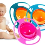 Bebé sonriente con plato giratorio anti derrames rosa y azul, ideal para comida.