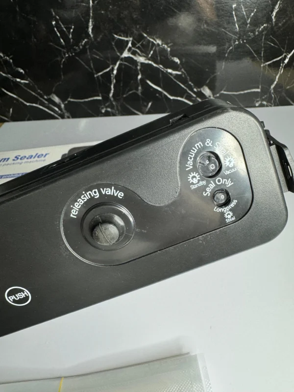 Selladora al vacío y 100 bolsas, con botones de operación "Vacuum & Seal" y "Seal Only".