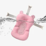 Cojín para bañera de bebé rosa flotando en agua, con correas.