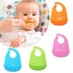 Baberos de silicona impermeables para bebé con diseño de animales en colores azul, verde y rosa.