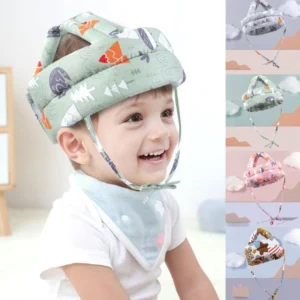 Niño sonriente con casco protector de cabeza suave y babero con estampado de árboles y animales.