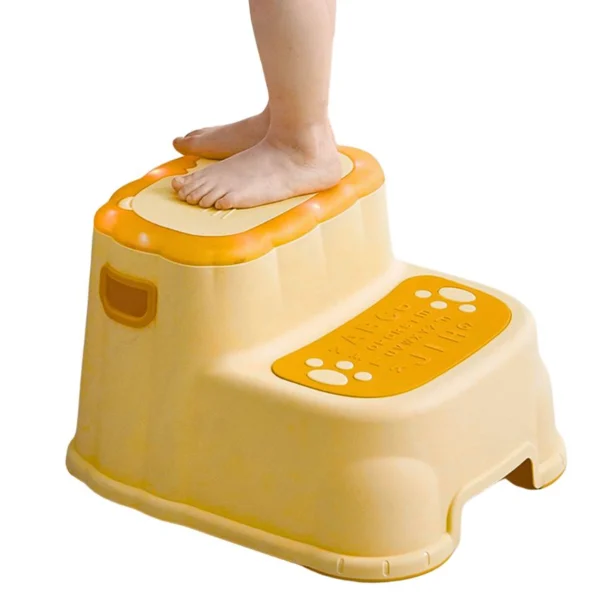 Niño en escalera de dos niveles amarilla con letras y huellas, ideal para baño.