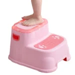 Escalera rosada de dos niveles para niños con huellas y luces, ideal para baño o cocina.
