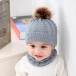 Gorro y bufanda tejidos para bebés, color gris con pompón marrón.
