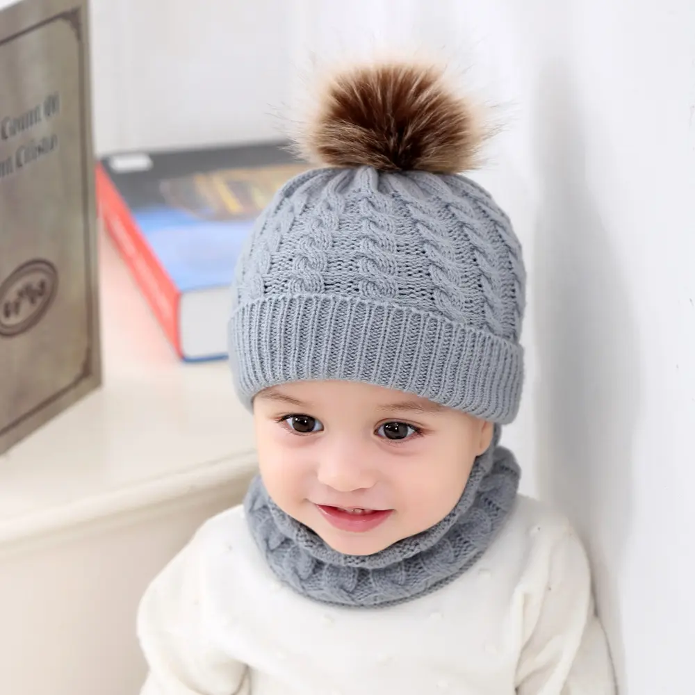 Gorro y bufanda tejidos para bebés, color gris con pompón marrón.