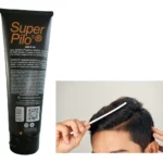 Shampoo Super Pilo® con peine sobre cabello oscuro y peinado hacia un lado.